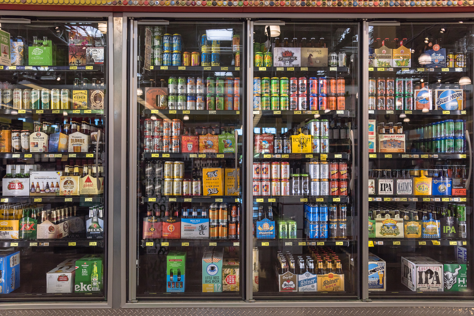 HOUSTON,US-OCT 9,2016:Various bottles of craft, microbrew, IPA, domestic and imported beers from around the world on shelf display in supermarket cooler. Alcohol drink background, different beer style